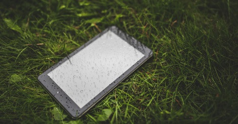 E-book olvasó a nedves fűben (illusztráció)